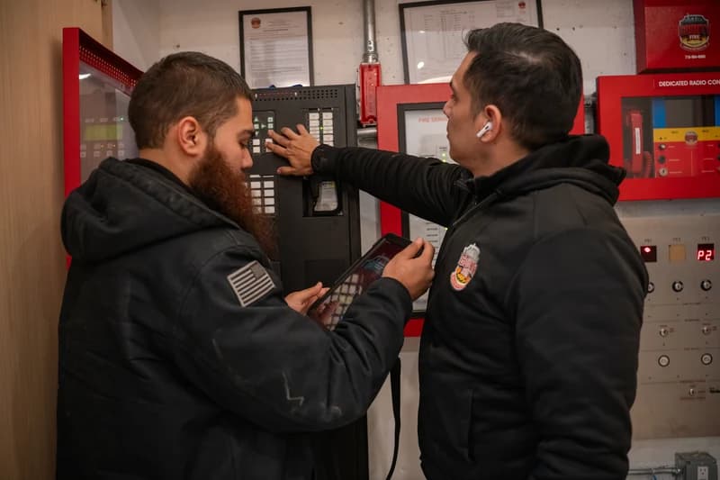 County Fire technicians programming and commissioning a fire alarm control panel during installation