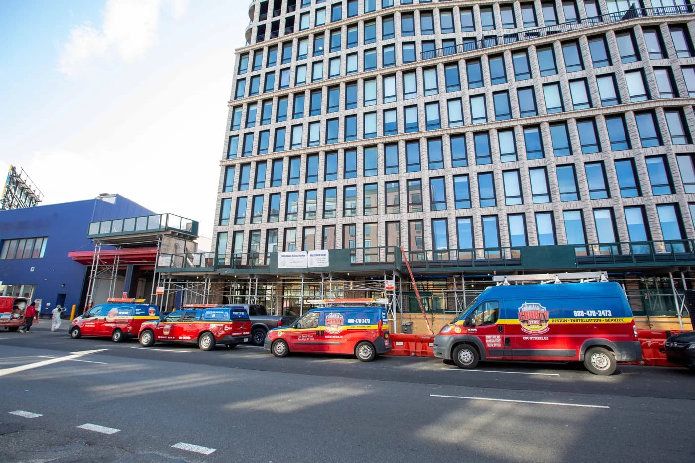 County Fire service vans lined up outside a Brooklyn jobsite on Atlantic Avenue