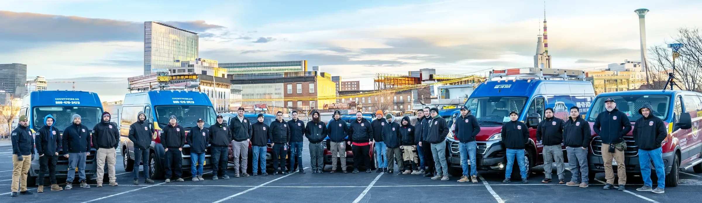 The County Fire team standing with their fleet of service vans