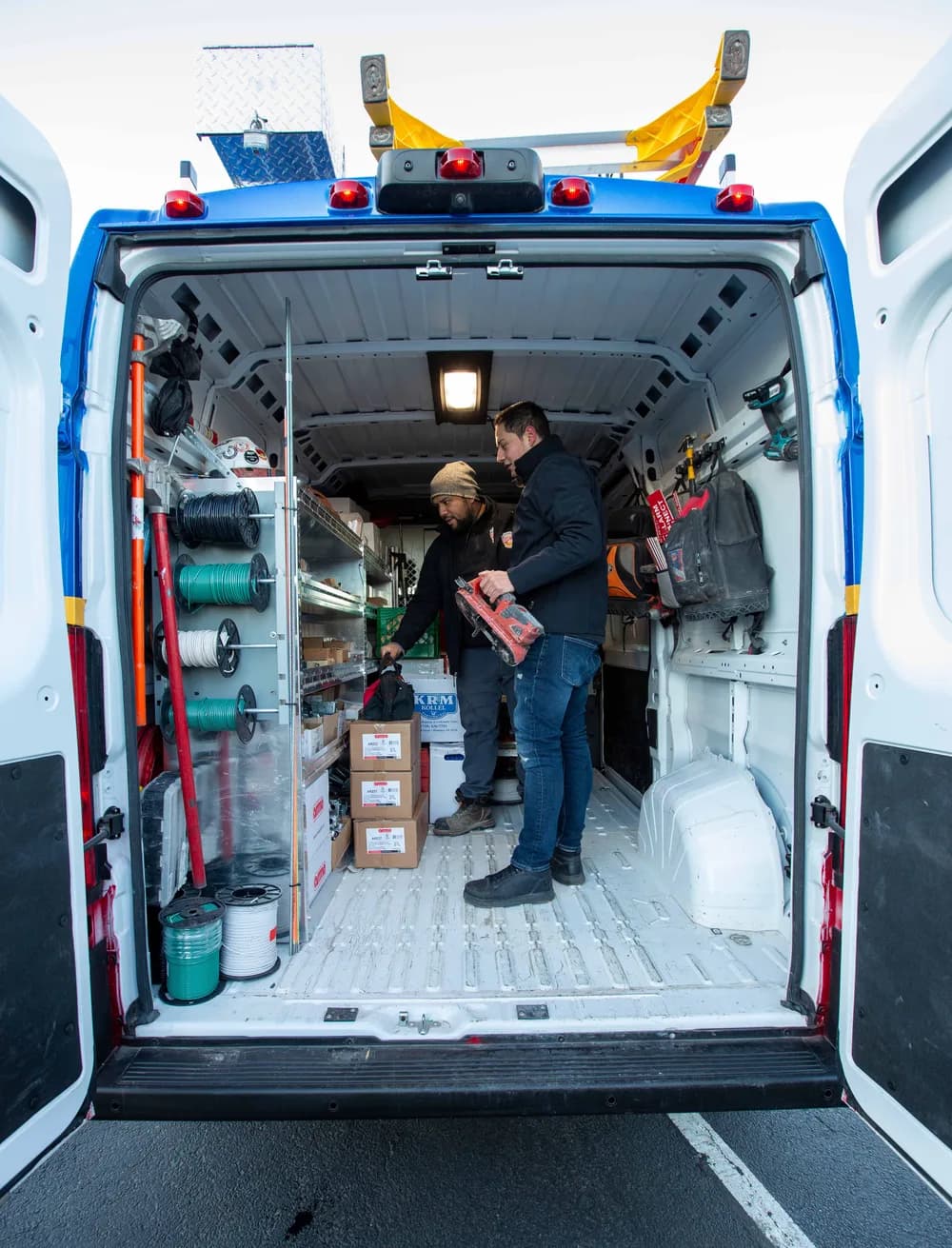Two County Fire technicians organizing equipment in the back of a service van in the Bronx
