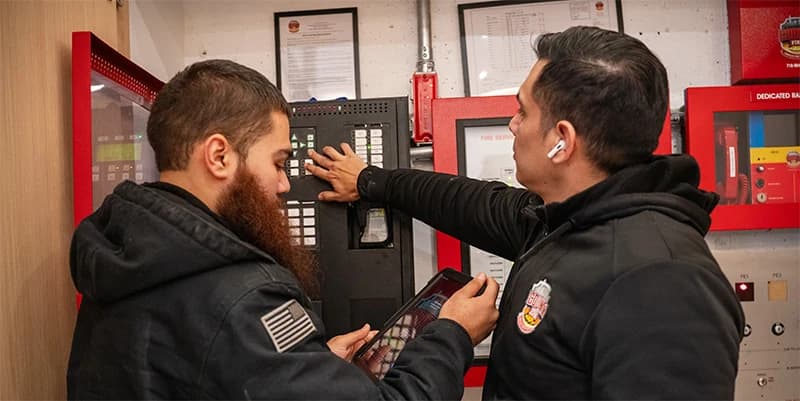 County Fire technician performing a fire alarm inspection in an NYC building