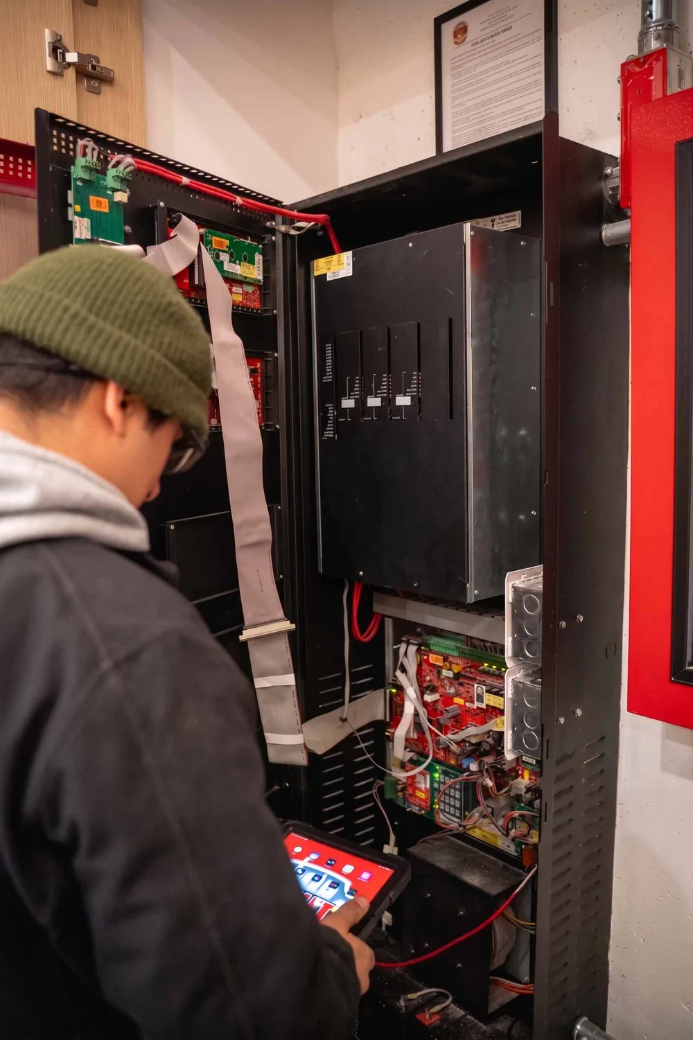 County Fire technician testing a fire alarm control panel with a tablet