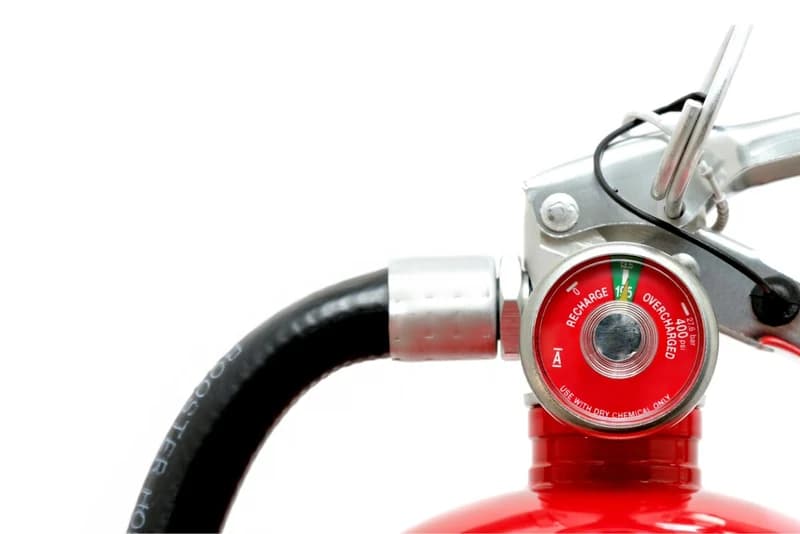 Close-up of a fire extinguisher pressure gauge checked during inspection