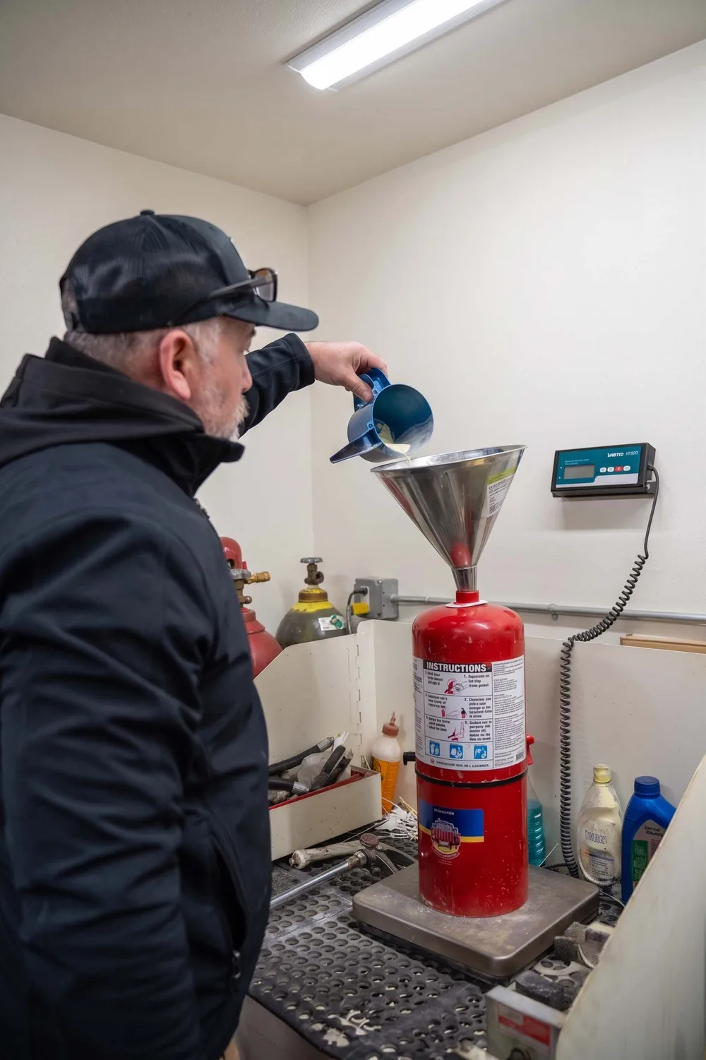 County Fire technician recharging a fire extinguisher in the service shop