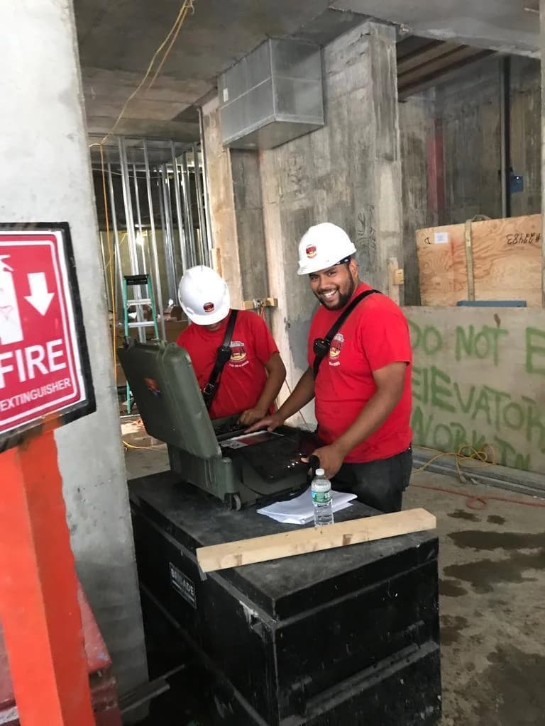 County Fire technicians servicing fire safety equipment on an active construction site