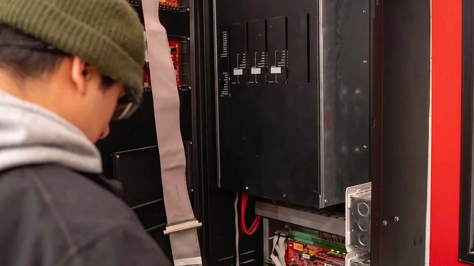 County Fire technician testing the internal boards of an open fire alarm panel